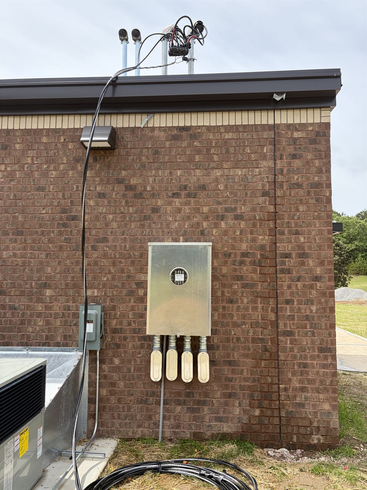 Commercial service entrance with meter, multiple conduit runs, and exterior disconnect